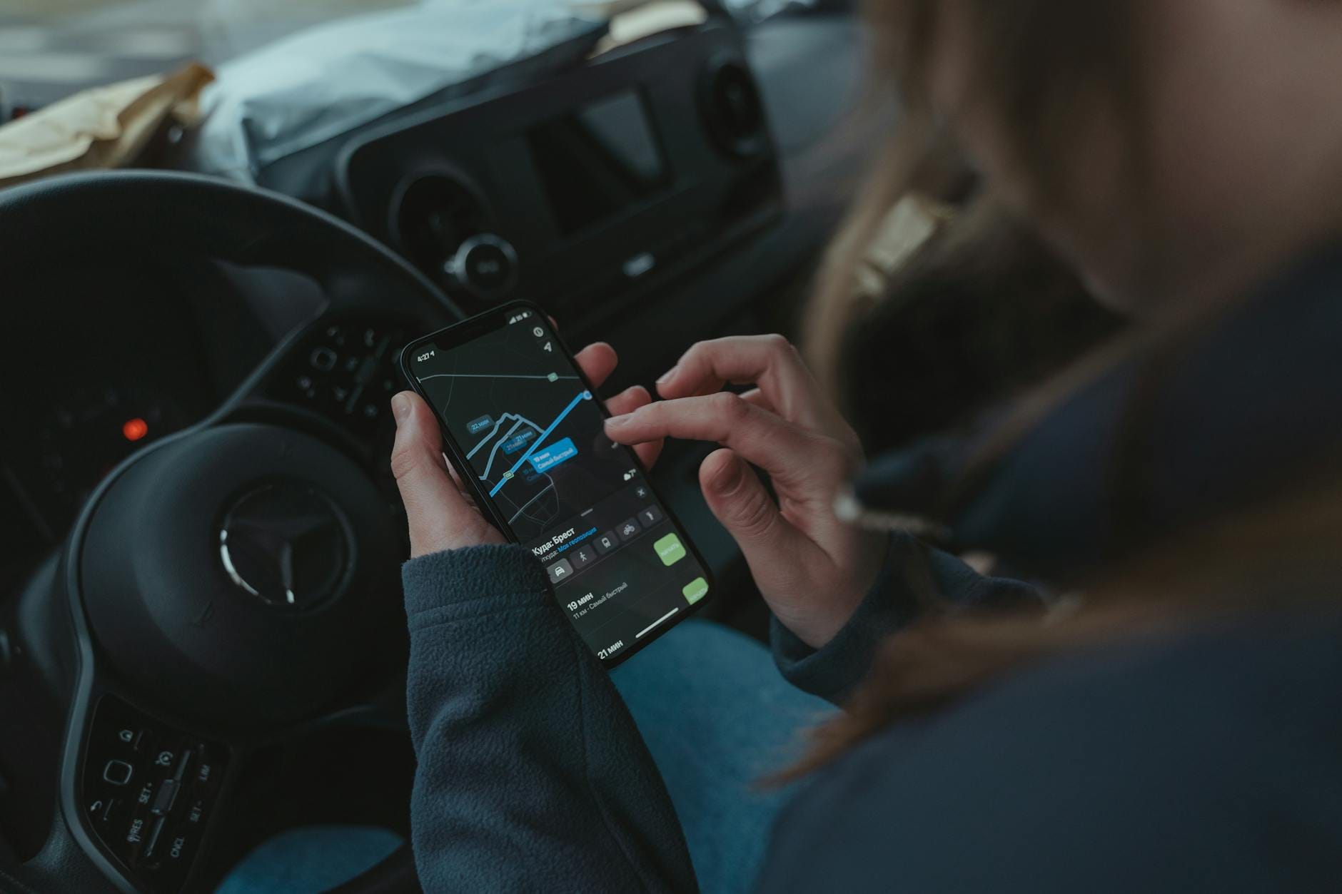 Kierowca korzysta z nawigacji GPS w smartfonie podczas jazdy samochodem