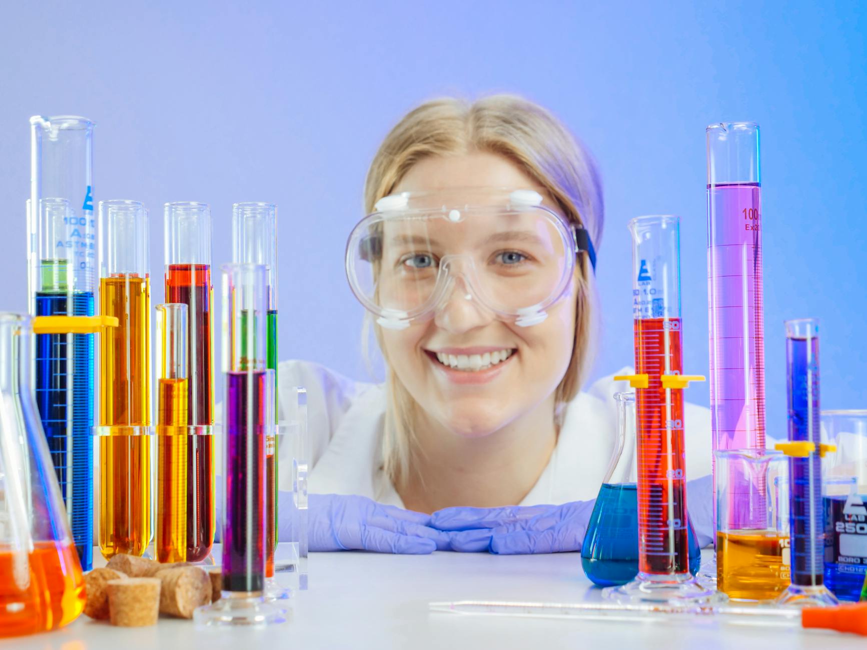 Maria Skłodowska-Curie – jak pasja do nauki zmieniła oblicze współczesnej fizyki i chemii Uśmiechnięta młoda badaczka przy probówkach z kolorowymi roztworami